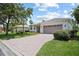 Beautiful single-story home with a brick paver driveway, lush lawn, and meticulously maintained landscaping at 759 Largo Pass, Poinciana, FL 34759