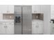 Modern kitchen featuring stainless steel appliances, sleek white cabinetry, and ample counter space at 759 Largo Pass, Poinciana, FL 34759
