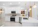 Modern kitchen featuring white cabinets, stainless steel appliances, granite countertops, and elegant lighting at 759 Largo Pass, Poinciana, FL 34759