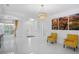 Elegant living room with white tile flooring, decorative lighting, and bright yellow armchairs at 759 Largo Pass, Poinciana, FL 34759