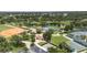 Aerial view features baseball field, tennis courts, shuffleboard, and green spaces, surrounded by trees and community at 759 Largo Pass, Poinciana, FL 34759