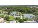 Aerial view showcasing tennis courts, shuffleboard, and recreation spaces surrounded by lush greenery and trees at 759 Largo Pass, Poinciana, FL 34759