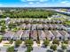 Aerial view of neighborhood with many houses, green space, and distant commercial area on a sunny day at 7613 Brookhurst Ln, Kissimmee, FL 34747