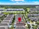 High aerial view of many houses with pools, and commercial area in the distance, with map pin in the foreground at 7613 Brookhurst Ln, Kissimmee, FL 34747
