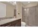 Modern bathroom featuring a granite vanity, ample lighting, and a glass-enclosed shower at 7613 Brookhurst Ln, Kissimmee, FL 34747