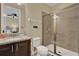 Bathroom featuring granite countertop, dark wood cabinets, and a glass enclosed shower at 7613 Brookhurst Ln, Kissimmee, FL 34747