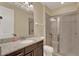 Bathroom featuring granite countertop, dark wood cabinets and a glass enclosed shower at 7613 Brookhurst Ln, Kissimmee, FL 34747
