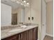 Bathroom featuring double sinks, granite countertop, and dark wood cabinets at 7613 Brookhurst Ln, Kissimmee, FL 34747