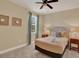 Bright bedroom with large window, ceiling fan, and neutral decor at 7613 Brookhurst Ln, Kissimmee, FL 34747
