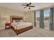 Cozy bedroom with ceiling fan, lamps, large bed, and blue curtains at 7613 Brookhurst Ln, Kissimmee, FL 34747