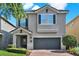 Charming two-story home features a brick driveway, well-manicured lawn, and a neutral-colored exterior at 7613 Brookhurst Ln, Kissimmee, FL 34747
