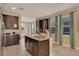 Spacious kitchen with granite countertops, stainless steel appliances, island with seating, and tile flooring at 7613 Brookhurst Ln, Kissimmee, FL 34747
