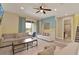 Cozy living room with tile flooring, a ceiling fan, and sliding glass doors leading to an outdoor pool area at 7613 Brookhurst Ln, Kissimmee, FL 34747