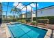 Beautiful in-ground pool with screened enclosure, adjacent to mature landscaping for a private backyard oasis at 7613 Brookhurst Ln, Kissimmee, FL 34747