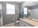 Well-lit bathroom with a large mirror, white vanity, and a shower-tub combination, offering a clean and functional design at 7751 Tosteth St, Kissimmee, FL 34747