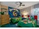 Cozy ' bedroom featuring twin beds, a ceiling fan, and playful Mickey Mouse decor at 7751 Tosteth St, Kissimmee, FL 34747