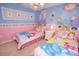 Charming bedroom with twin beds, pink accents, and delightful princess-themed decor at 7751 Tosteth St, Kissimmee, FL 34747