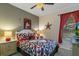 A playful bedroom with a ceiling fan, red accents, and decorative touches, creating a whimsical and inviting atmosphere at 7751 Tosteth St, Kissimmee, FL 34747