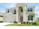 Charming two-story home featuring an attached two car garage, lush landscaping, and welcoming front entryway at 7751 Tosteth St, Kissimmee, FL 34747