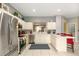 Modern kitchen featuring white cabinetry, stainless steel appliances, and an island with a breakfast bar at 7751 Tosteth St, Kissimmee, FL 34747