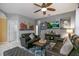 Comfortable living room featuring tile flooring, ceiling fan, large window and leather furniture at 7751 Tosteth St, Kissimmee, FL 34747