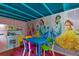 Playroom with colorful princess wall, play kitchen, table and chairs at 7751 Tosteth St, Kissimmee, FL 34747
