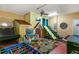Vibrant playroom featuring slides, toy kitchen, and engaging play area for children at 7751 Tosteth St, Kissimmee, FL 34747