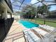 Inviting screened-in pool and spa with ample patio space, perfect for entertaining and outdoor enjoyment at 7751 Tosteth St, Kissimmee, FL 34747