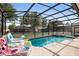 Inviting pool with screened enclosure, comfortable loungers, and refreshing ambiance at 7751 Tosteth St, Kissimmee, FL 34747