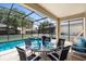 Screened-in lanai with a table set for dinner next to a swimming pool and hot tub at 7751 Tosteth St, Kissimmee, FL 34747