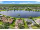 Stunning aerial view of home with lake frontage and lush green landscape; wooded area in the distance at 777 Glendora Road, Poinciana, FL 34759