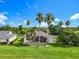Expansive backyard features a screened-in lanai, lush lawn, and mature palm trees at 777 Glendora Road, Poinciana, FL 34759