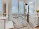 Modern bathroom featuring a marble-tiled walk-in shower with rainfall shower head and a comfortable built-in bench at 777 Glendora Road, Poinciana, FL 34759