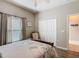 Cozy bedroom with wood-look flooring, a comfortable chair, and a full closet for ample storage at 777 Glendora Road, Poinciana, FL 34759
