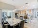 Open-concept dining room featuring a marble table, bar seating, and views into the living room at 777 Glendora Road, Poinciana, FL 34759