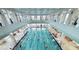 An Indoor pool with a net and natural lighting coming from surrounding large windows at 777 Glendora Road, Poinciana, FL 34759