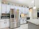 Bright kitchen with stainless steel refrigerator, granite countertops, and white cabinetry at 777 Glendora Road, Poinciana, FL 34759
