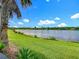 Breathtaking lake view with lush green lawn and tropical foliage in this waterfront property at 777 Glendora Road, Poinciana, FL 34759