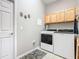 Practical laundry room with modern appliances, overhead storage, and stylish decor accents for a functional space at 777 Glendora Road, Poinciana, FL 34759