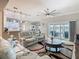 Bright and open living room with a view of the kitchen, a cozy sofa, and access to an outdoor patio at 777 Glendora Road, Poinciana, FL 34759