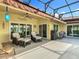 Inviting screened-in patio with comfortable seating, a ceiling fan, and serene views of the surrounding waterfront at 777 Glendora Road, Poinciana, FL 34759