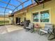 Relaxing screened-in patio featuring comfortable seating, a grill, and tranquil views of the surrounding landscape at 777 Glendora Road, Poinciana, FL 34759