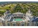 Stunning aerial view of a luxurious resort rooftop pool with inviting lounge areas and lush golf courses in the background at 7802 Palmilla Ct, Reunion, FL 34747
