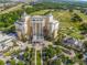 Resort aerial view showing a hotel, putting green, and lush landscaping, close to the golf course, and mature trees at 7802 Palmilla Ct, Reunion, FL 34747
