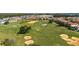 Panoramic aerial view showcasing a beautifully maintained golf course lined with luxury homes and lush greenery at 7802 Palmilla Ct, Reunion, FL 34747