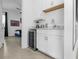 Wet bar featuring white cabinetry, stainless steel appliances and a bedroom in the background at 7802 Palmilla Ct, Reunion, FL 34747