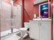 Red themed bathroom with a glass enclosed shower, tile surround and a white vanity at 7802 Palmilla Ct, Reunion, FL 34747