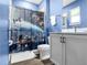 Bright blue bathroom with white vanity and framed mirror, featuring a Star Wars themed shower curtain at 7802 Palmilla Ct, Reunion, FL 34747