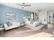 Stylish bedroom featuring blue accent wall, modern furniture, and wood-look floors at 7802 Palmilla Ct, Reunion, FL 34747