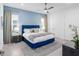 A stylish blue bedroom is shown with a tufted headboard, soft rug, and neutral curtains, offering a serene retreat at 7802 Palmilla Ct, Reunion, FL 34747